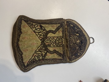 An Iranian gold-thread-embroidered silk caftan, a hat, a coin bracelet and a Koran holder, 19th C.