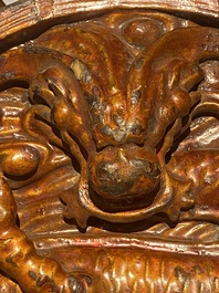 A pair of Chinese gilt-lacquered wooden guardians and a round 'dragon' plaque, 19th C.