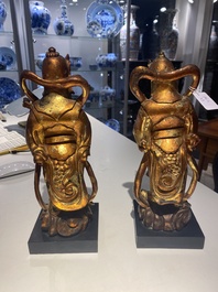 A pair of Chinese gilt-lacquered wooden guardians and a round 'dragon' plaque, 19th C.
