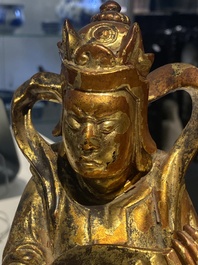 A pair of Chinese gilt-lacquered wooden guardians and a round 'dragon' plaque, 19th C.