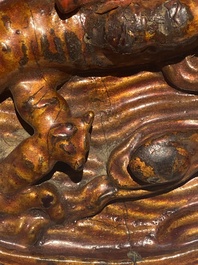 A pair of Chinese gilt-lacquered wooden guardians and a round 'dragon' plaque, 19th C.