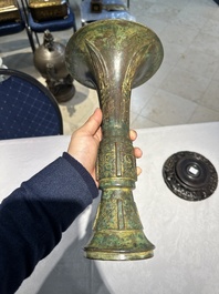 Een Chinese bronzen Shang-stijl 'gu' vaas op houten sokkel, 19/20e eeuw