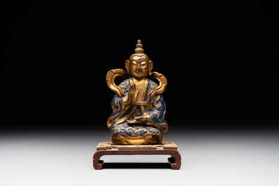 A Chinese gilt and champlev&eacute; enamelled bronze Bodhisattva on a carved stone stand, Qing