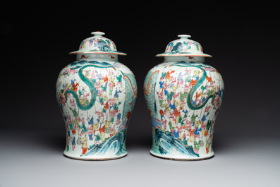 A pair of Chinese famille rose 'hundred boys' vases and covers on wooden stands, 19th C.