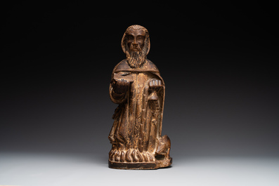 A large Burgundian stone sculpture of Saint Anthony the Great with attributes, France, 14th C.