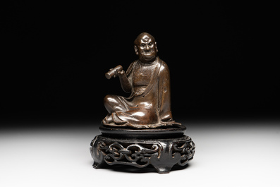 A small Chinese bronze figure of a Luohan, Ming