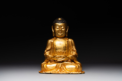 A large Sino-Tibetan gilt bronze Buddha on wooden stand, Ming