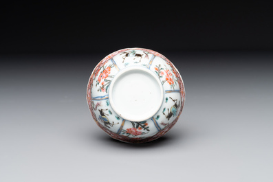A Chinese famille rose cup and saucer with figures and animals, Yongzheng