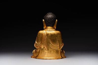 A large Sino-Tibetan gilt bronze Buddha on wooden stand, Ming