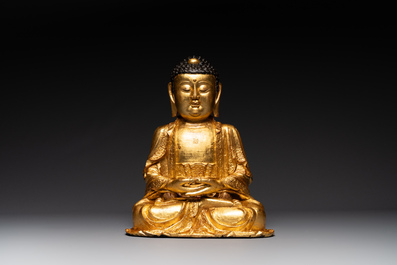 A large Sino-Tibetan gilt bronze Buddha on wooden stand, Ming
