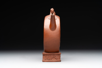 A Chinese circle-shaped Yixing stoneware 'kylin' teapot with relief design, Kangxi