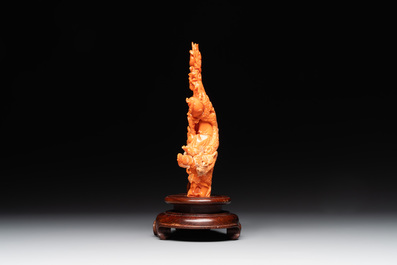 A Chinese red coral group of Shoulao with two boys holding a peach, inscribed 'Shou Bi Nan Shan 壽比南山', 19/20th C.
