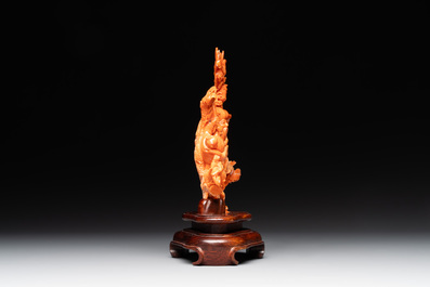 A Chinese red coral group of Shoulao with two boys holding a peach, inscribed 'Shou Bi Nan Shan 壽比南山', 19/20th C.