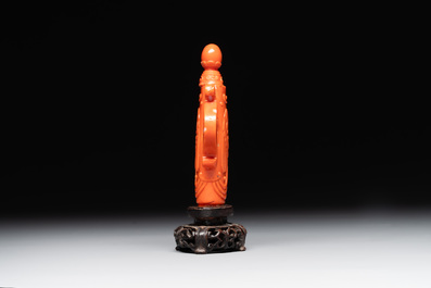 A Chinese carved red coral ewer and cover on wooden stand, 19th C.