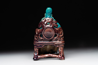A Chinese turquoise- and aubergine-glazed sculpture of a seated scholar, 18/19th C.