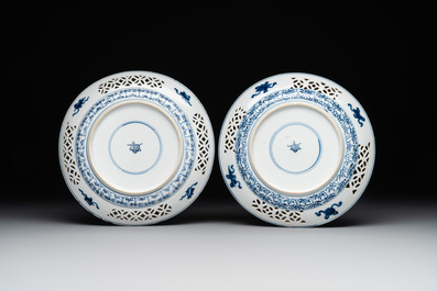 A pair of Chinese blue and white plates with floral design and reticulated border, conical shell mark, Kangxi