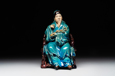 A Chinese turquoise- and aubergine-glazed sculpture of a seated scholar, 18/19th C.