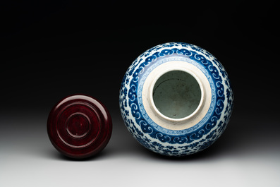 A Chinese blue and white 'flower scroll' jar with a wooden cover, Qianlong
