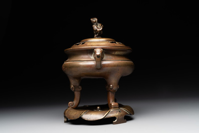 A Chinese bronze tripod censer with cover and stand, 19th C.