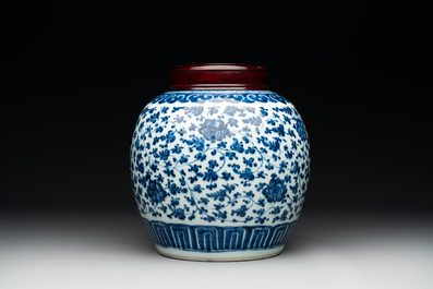 A Chinese blue and white 'flower scroll' jar with a wooden cover, Qianlong