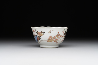 A Chinese polychrome cup and saucer with figures and a dog, Yongzheng