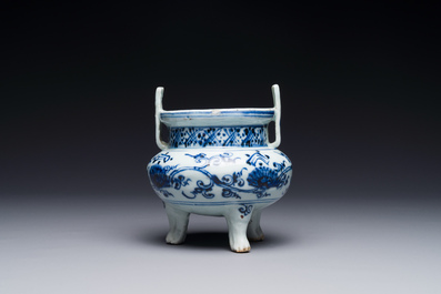 A Chinese blue and white tripod censer with floral design and a wooden cover, Ming