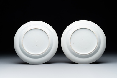 A pair of Chinese Canton famille rose plates with figures in a garden, 19th C.