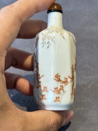 A Chinese iron-red and grisaille snuff bottle with monkeys at the Shuilian cave, 19th C.