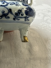 A Chinese blue and white tripod censer with floral design and a wooden cover, Ming