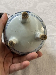 A Chinese blue and white tripod censer with floral design and a wooden cover, Ming