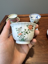 A pair of Chinese famille verte and a pair of famille rose cups and saucers, Kangxi/Yongzheng