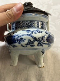 A Chinese blue and white tripod censer with floral design and a wooden cover, Ming