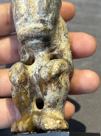 A Chinese jade carving of a crouched figure, possibly Hongshan culture