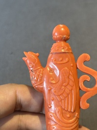 A Chinese carved red coral ewer and cover on wooden stand, 19th C.