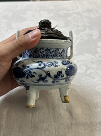 A Chinese blue and white tripod censer with floral design and a wooden cover, Ming