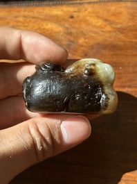 A Chinese celadon and russet jade mythical beast carving, Ming