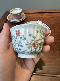 A pair of Chinese famille verte and a pair of famille rose cups and saucers, Kangxi/Yongzheng