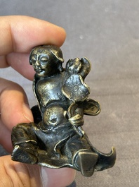 A Chinese bronze paperweight in the form of 'Shi De 拾得' on wooden stand, 16th C.