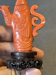 A Chinese carved red coral ewer and cover on wooden stand, 19th C.
