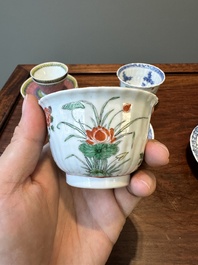 A pair of Chinese famille verte and a pair of famille rose cups and saucers, Kangxi/Yongzheng