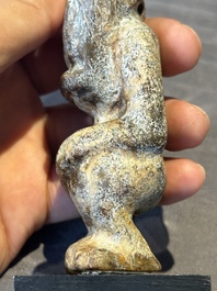 A Chinese jade carving of a crouched figure, possibly Hongshan culture