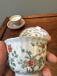 A pair of Chinese famille verte and a pair of famille rose cups and saucers, Kangxi/Yongzheng
