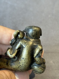 A Chinese bronze paperweight in the form of 'Shi De 拾得' on wooden stand, 16th C.