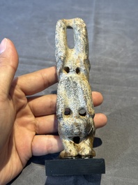 A Chinese jade carving of a crouched figure, possibly Hongshan culture