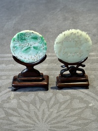 Two Chinese round jade plaques on carved wooden stands, 19th C.