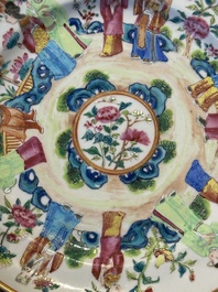 A pair of Chinese Canton famille rose plates with figures in a garden, 19th C.