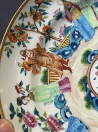 A pair of Chinese Canton famille rose plates with figures in a garden, 19th C.