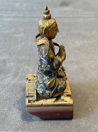 A Chinese gilt and champlev&eacute; enamelled bronze Bodhisattva on a carved stone stand, Qing