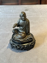 A small Chinese bronze figure of a Luohan, Ming