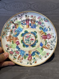 A pair of Chinese Canton famille rose plates with figures in a garden, 19th C.